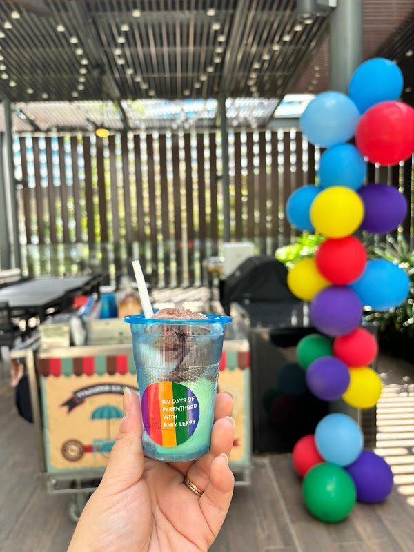 Colorful layered dessert drink at festive balloon-decorated event
